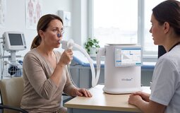 Patient performing pulmonary function testing on a Minibox+ system